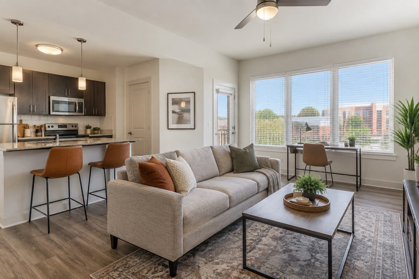 A bright apartment living room with a sofa, coffee table and kitchen island.